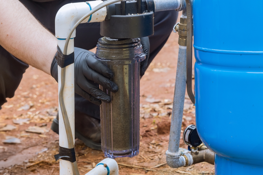 Worker replaces filter at domestic water treatment facility