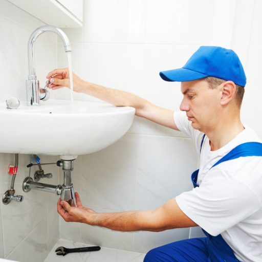 plumber worker working with spanner during leaky faucet tap repair