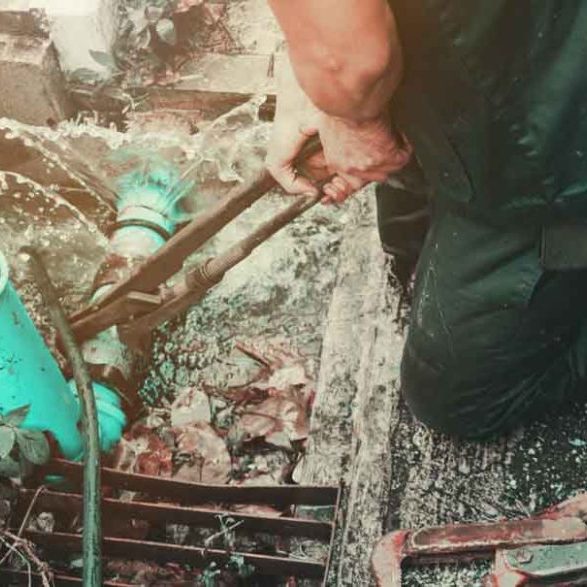 plumber working repair the broken pipe with Adjustable Wrenches or Locking Pliers in hole ditch at roadside and water Motion