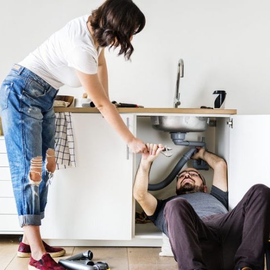 Couple fixing kitchen sink