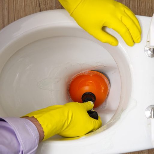 Man cleaning overflowing broken toilet. clogged toilet
