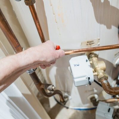 plumber adjusting central heating boiler valve
