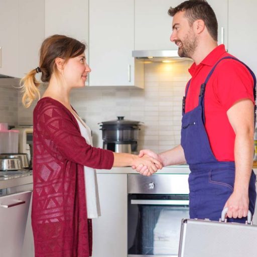 Satisfied housewife handshaking after plumber quick service
