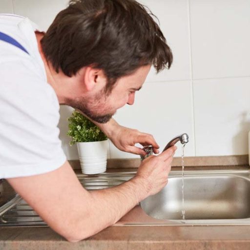 plumber replacing kitchen faucet