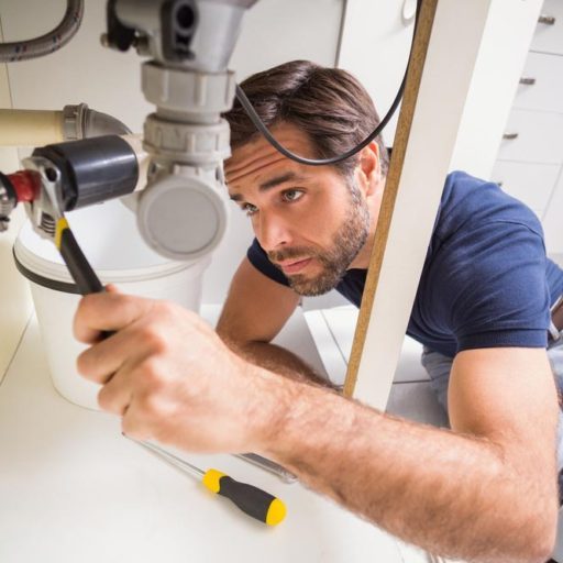 Plumber fixing pipe under sink Stamford, CT