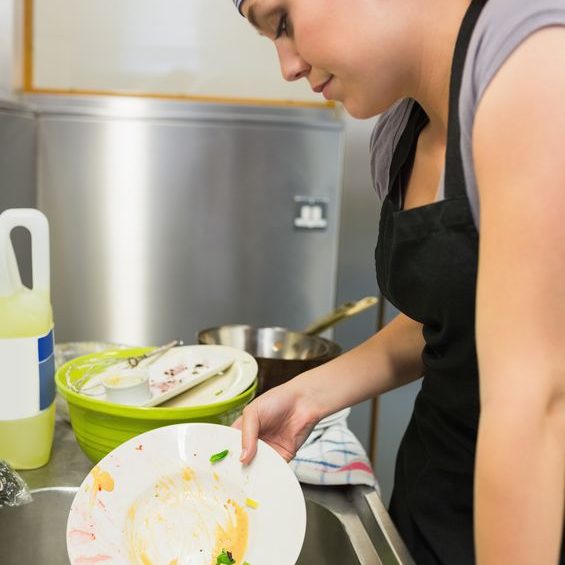 20517409 - unsmiling woman washing a plate in the restaurant